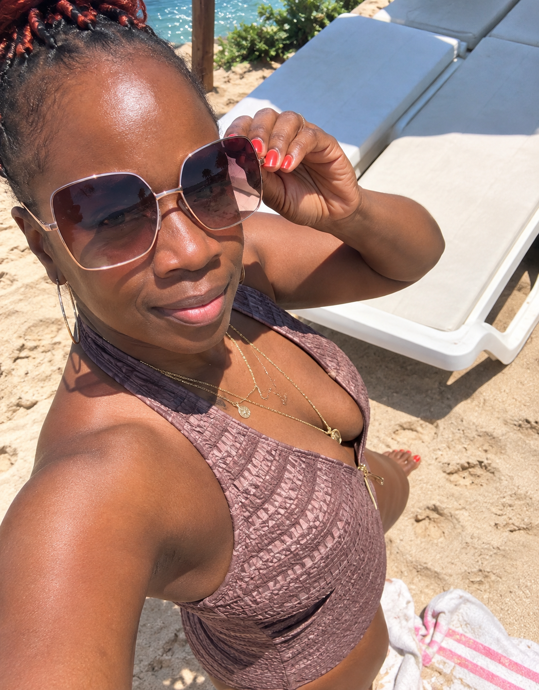 Anna taking a sunny beach selfie in sunglasses